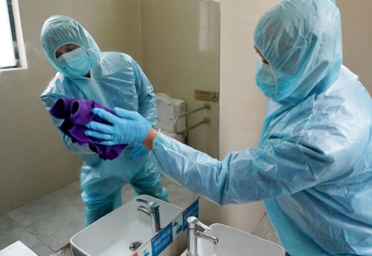 ↑ 2月8日，苏启云在公厕内擦镜子。今年54岁的苏启云是武汉市众多“守厕人”中的一个。他负责武展东路公共厕所的保洁和消毒。