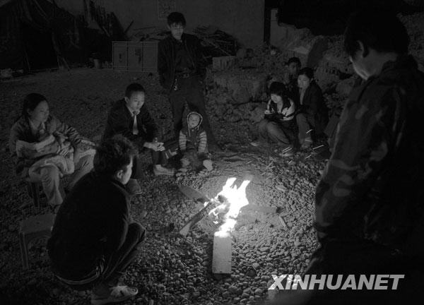 2008年5月13日凌晨，几位陇南受灾群众在烤火取暖。