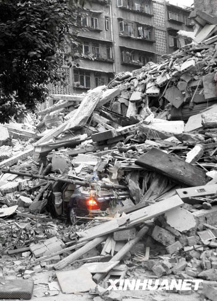 2008年5月12日，成都都江堰市一辆被埋在垮塌废墟里的汽车车灯仍在闪烁（经技术处理）。