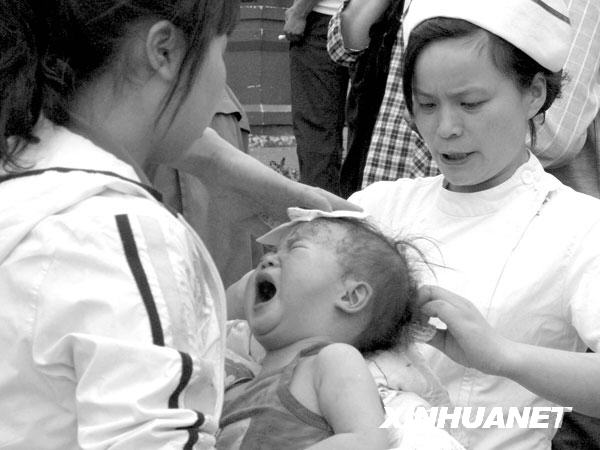 2008年5月12日14时43分，医务人员在都江堰市人民医院门前救护受伤的婴儿。